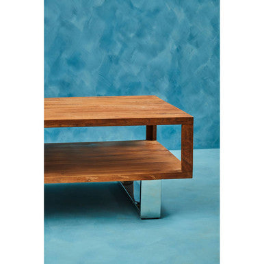 Brown acacia wood coffee table styled beside a sofa