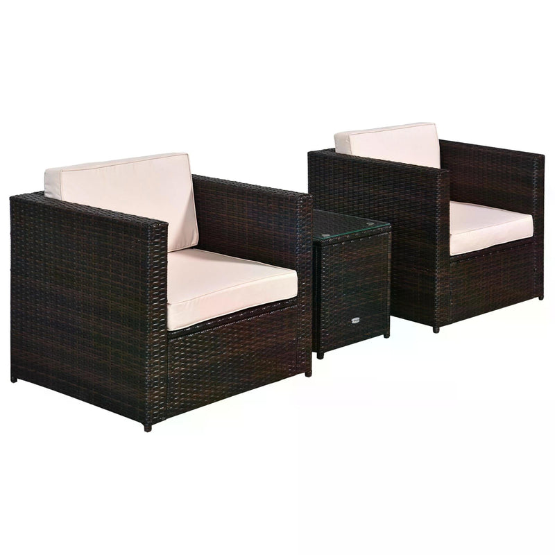 Two brown rattan armchairs with cream cushions and a glass-top side table on a white background