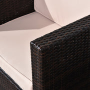 Close-up of the cream seat cushion meeting the rattan armrest of the armchair