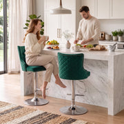Woman seated on a dark green button-tufted bar stool at a marble kitchen island