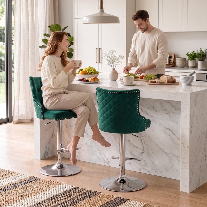 Woman seated on a dark green button-tufted bar stool at a marble kitchen island