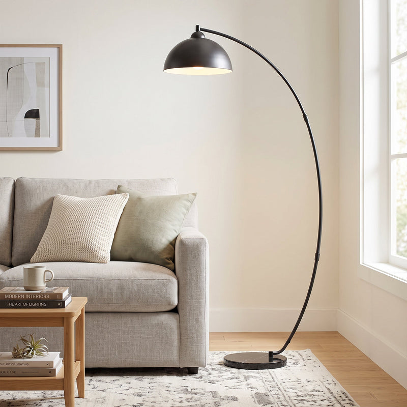 Black arc floor lamp beside a sofa in a living room