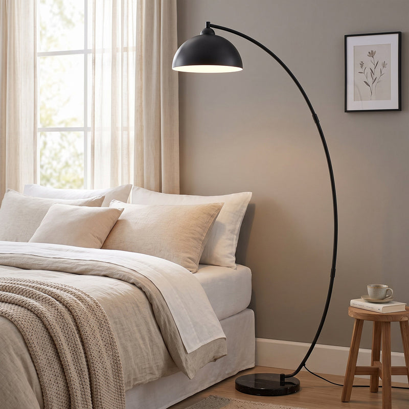 Arc floor lamp beside a bed in a bedroom