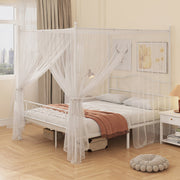 White bed frame with a sheer mosquito net draped over the posts