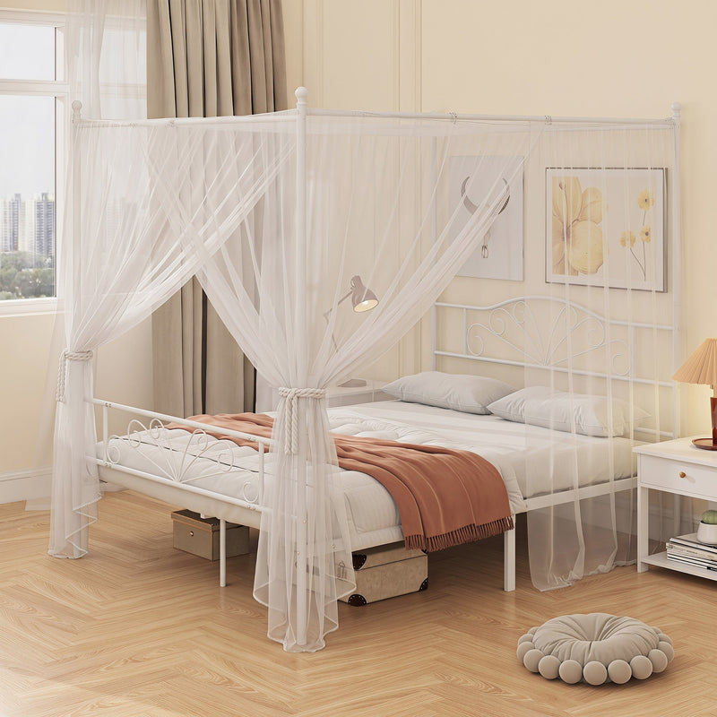 White bed frame with a sheer mosquito net draped over the posts