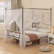 Black canopy bed frame with white sheer canopy drapes in a bedroom