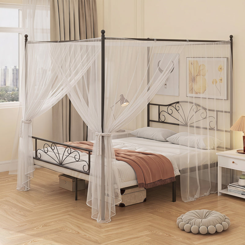 Black canopy bed frame with white sheer canopy drapes in a bedroom