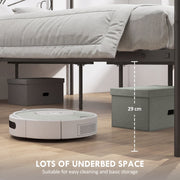 Underbed storage space beneath a black canopy bed frame with storage boxes