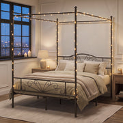 Black canopy bed frame with fairy lights in a cosy bedroom at night