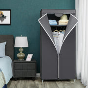 Grey canvas wardrobe standing beside a bed and table lamp against a teal bedroom wall