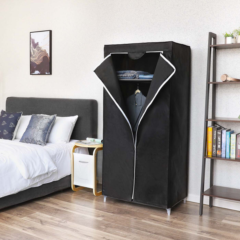 Black canvas wardrobe standing beside a double bed and a ladder bookshelf in a bedroom