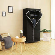 Black canvas wardrobe in a living room next to a round wooden coffee table and an armchair