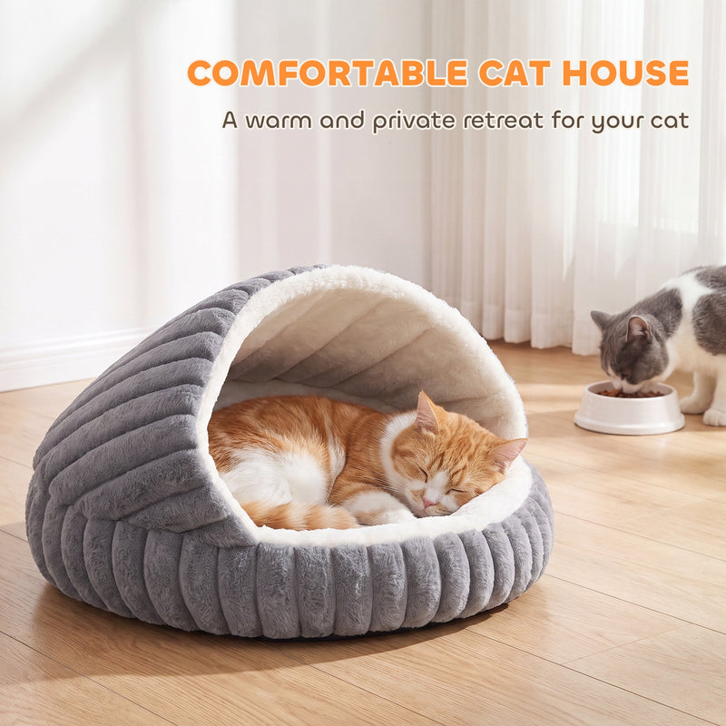 Ginger and white cat curled up asleep inside the cat cave bed