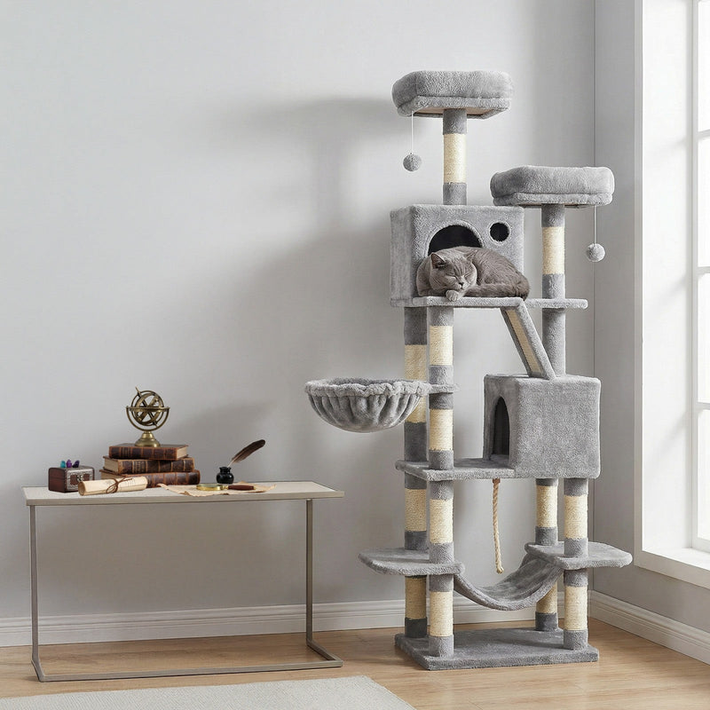 Light grey cat tree beside a desk with a grey cat asleep in the upper cave