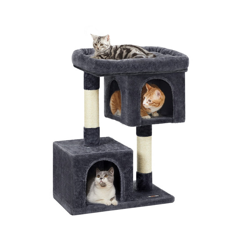 Studio shot of the Feandrea 84cm cat tree tower with three cats using the top perch and both caves
