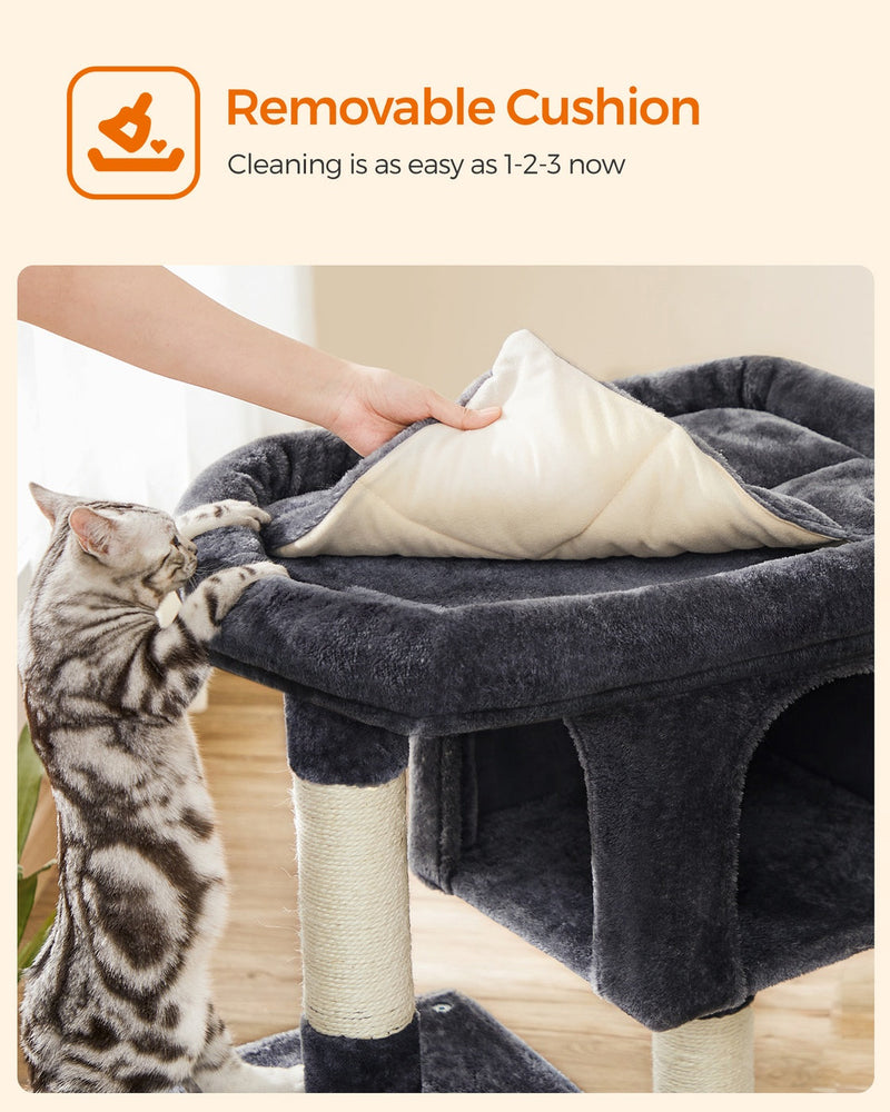 Hand removing the top cushion of the cat tree to show it is removable for cleaning