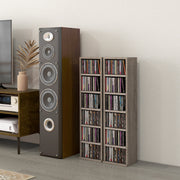 Two filled CD towers next to a floor-standing speaker