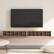Towers laid flat on a shelf beneath a wall-mounted TV