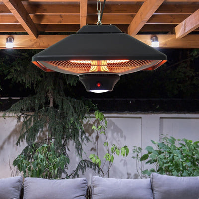 Black hanging halogen patio heater glowing under a wooden pergola at night
