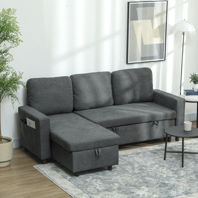 Charcoal grey L-shaped sofa bed styled in a living room with a plant and floor lamp