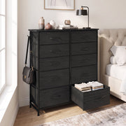 Black chest of drawers in a bedroom with one drawer pulled out