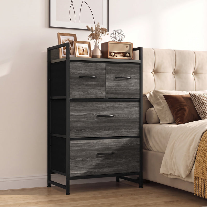 Slim chest of drawers used as a bedside unit with a radio and picture frames