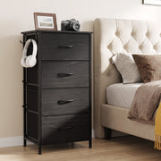 Black 4 drawer fabric chest used as a bedside table next to a bed