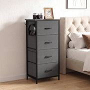 Chest of drawers beside a tufted bed with headphones on the side hook, shown in grey
