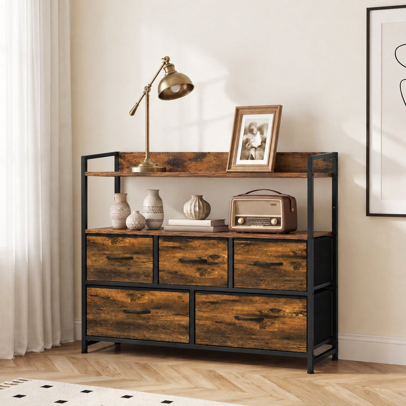 Rustic brown 5-drawer chest of drawers in a living room with a lamp and framed photo on the top shelf