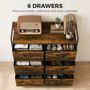 Chest of drawers with six open drawers showing folded towels, underwear and socks