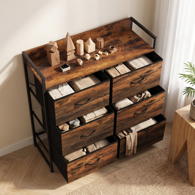 Angled view of the chest of drawers with open drawers holding folded clothes