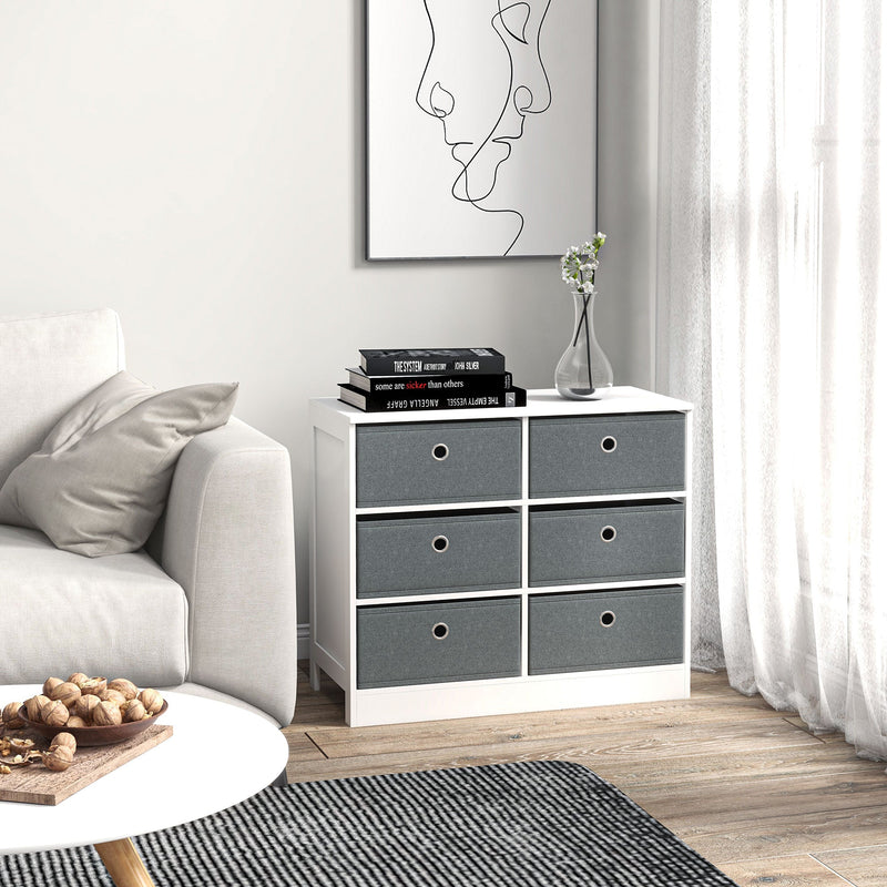Fabric chest of drawers in a living room beside a sofa with books and a vase on top