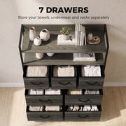 Grey chest of drawers with towels, underwear and socks neatly stored in the seven fabric drawers