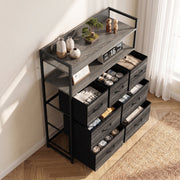 Grey chest of drawers seen from above at an angle with socks and clothes stored in the open drawers