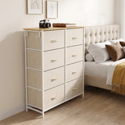 Beige fabric chest of drawers styled as a bedside unit next to a bed