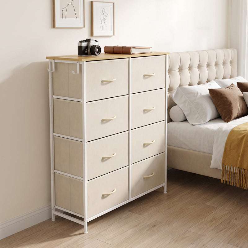 Beige fabric chest of drawers styled as a bedside unit next to a bed