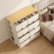 Angled view of open drawers beside a bed showing folded clothing storage