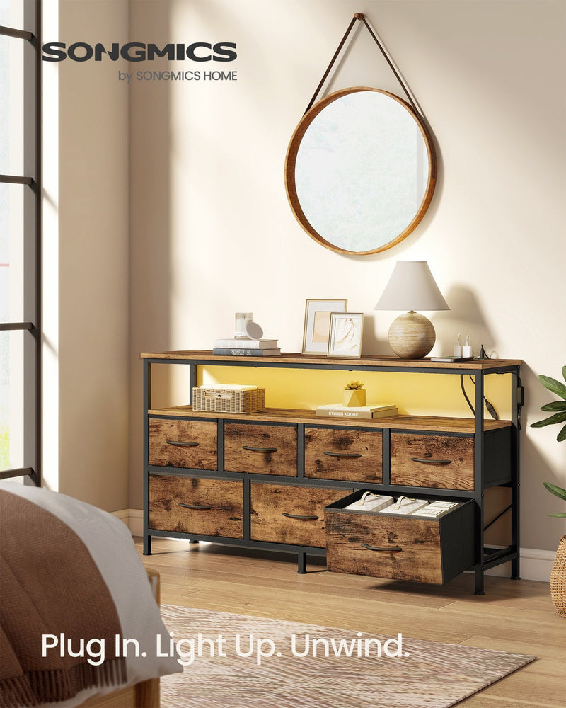 Rustic brown chest of drawers with charging station styled in a bedroom next to a round mirror, LED shelf lit