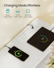 Close-up of the chest's built-in power console charging a smartphone and tablet via two AC outlets, one USB-A and one USB-C port.