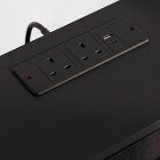 Close-up of the two UK outlets and USB ports in the black top panel