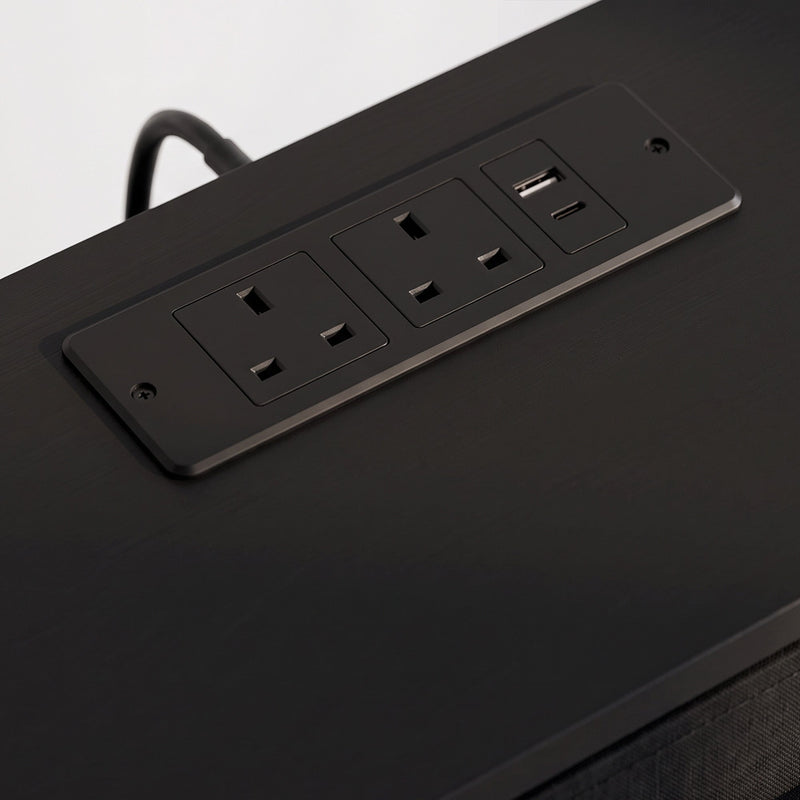 Close-up of the two UK outlets and USB ports in the black top panel