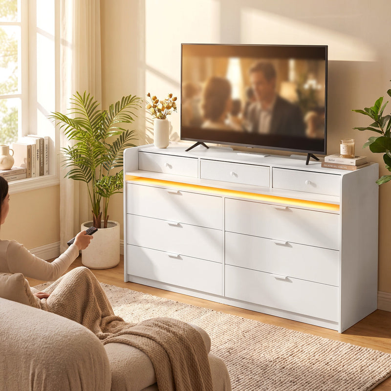White chest of drawers under a TV in a living room with a warm LED glow