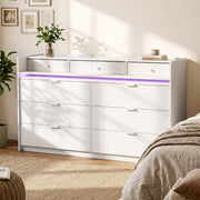 White chest of drawers with purple LED strip beside a bed
