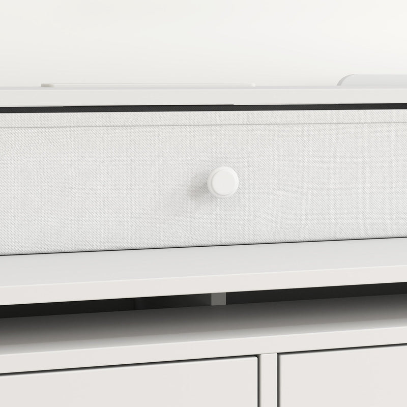Close-up of a small top drawer with a fabric-look front and round knob in white