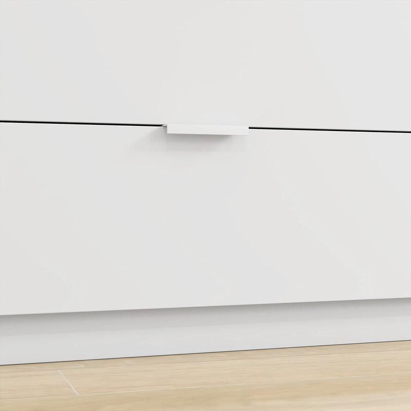 Close-up of a white drawer front with a slim handle above the base