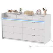White chest of drawers on a plain background with books, clock and brushes on top