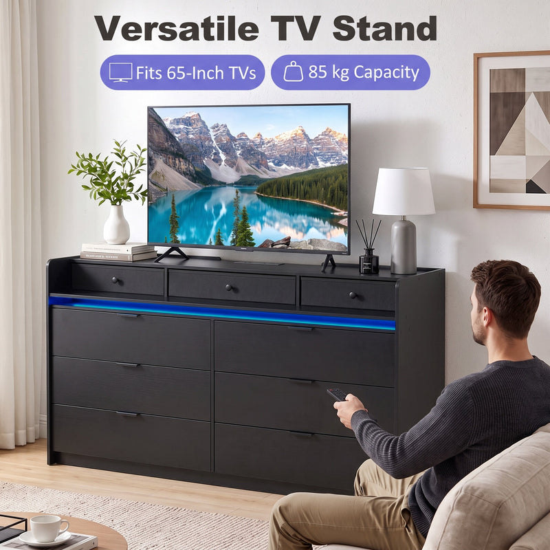 Black chest of drawers used as a TV stand holding a 65 inch TV