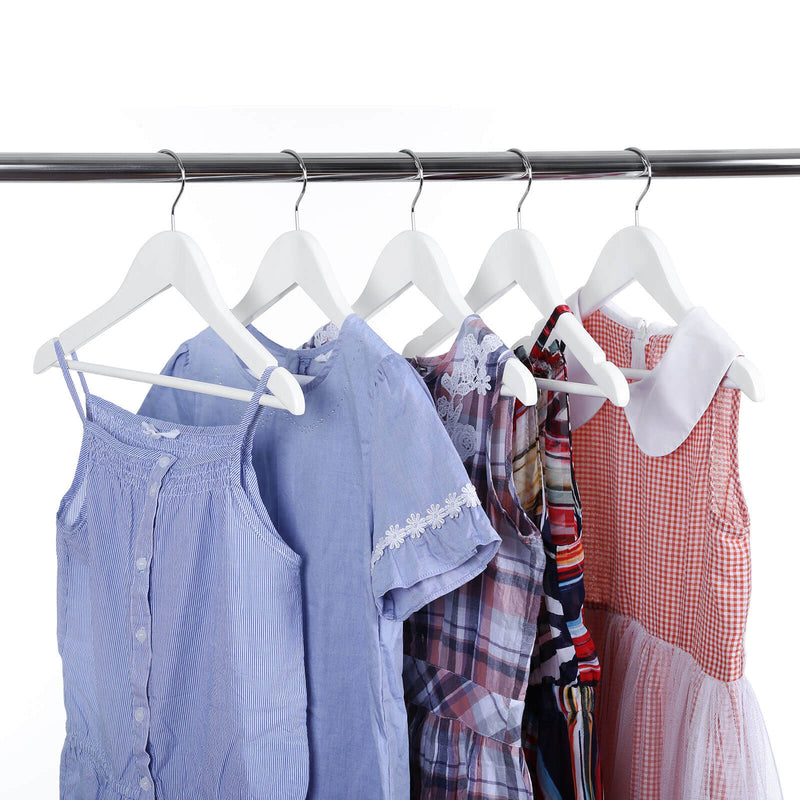 Children's shirts and dresses on white wooden hangers on a rail