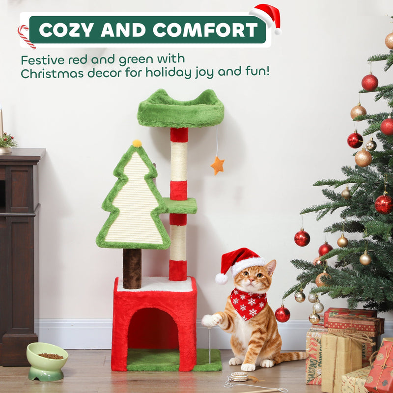 Cat tree with a ginger cat in a Santa bandana playing beside the cat house