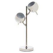 Chrome table lamp with two round shades on a plain background